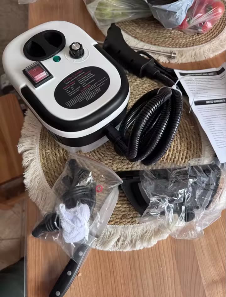 Limpiador a vapor con sus accesorios sobre la mesa